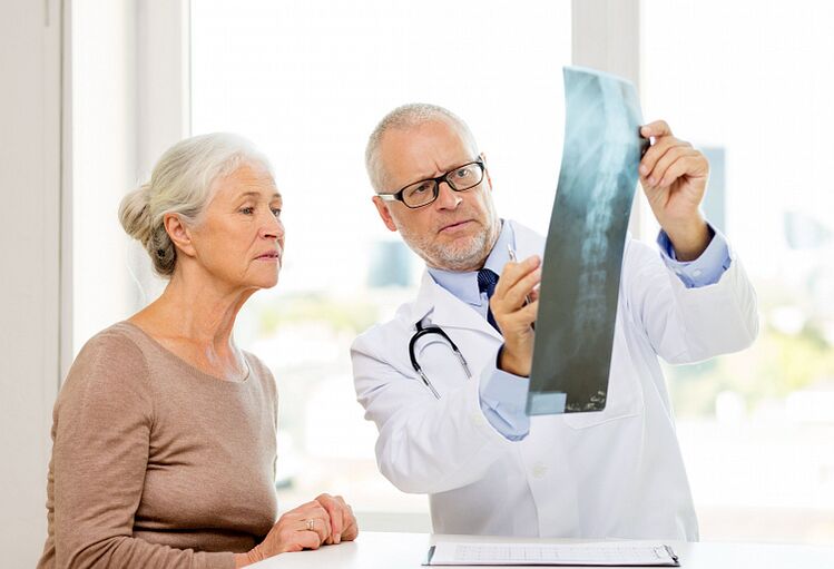 Den Dokter bestëmmt zervikal Osteochondrose bei engem Patient mat Hëllef vun Radiographie